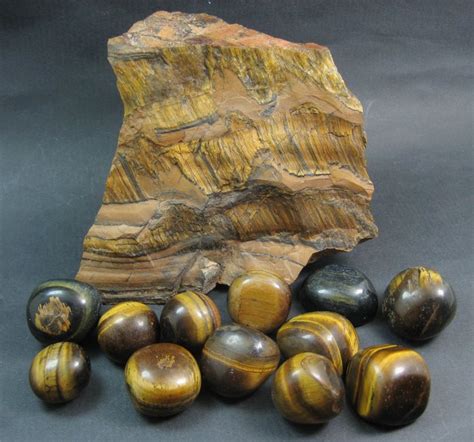 A natural Tigers Eye rock specimen together with 12 Tigers Eye polished ...