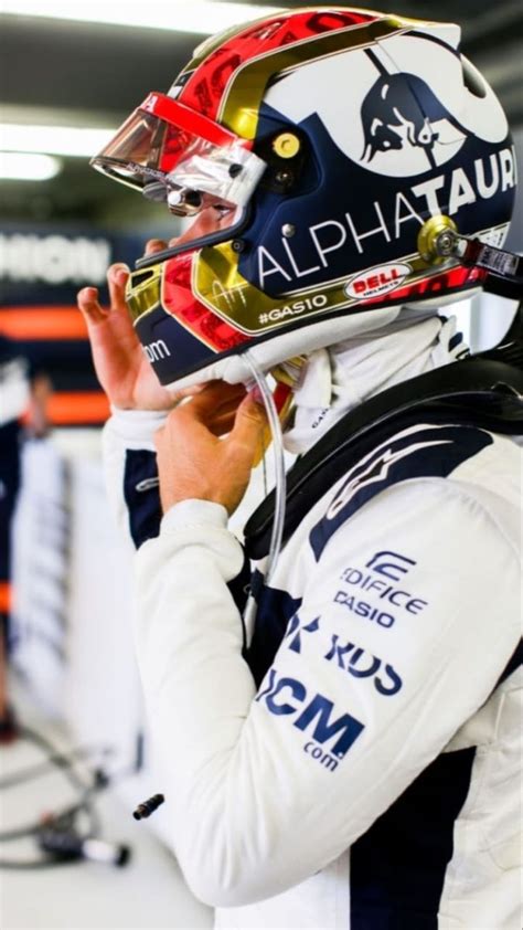 a man with a helmet on talking on his cell phone while wearing a racing ...