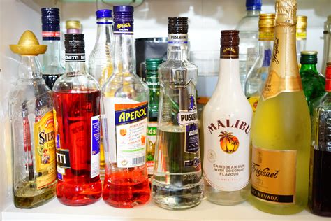 liquor bottle collection on white shelf free image | Peakpx