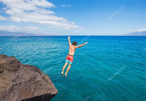 Man jumping off cliff into the ocean — Stock Photo © EpicStockMedia #49705663