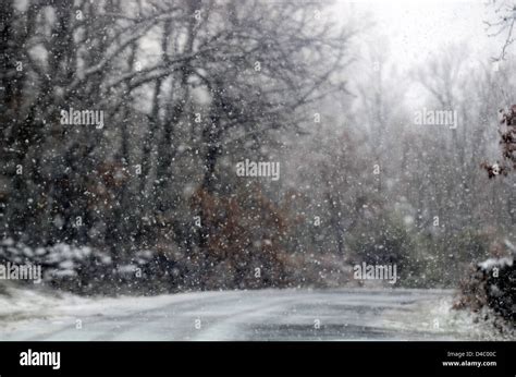 Snow falling in mountain road Stock Photo - Alamy