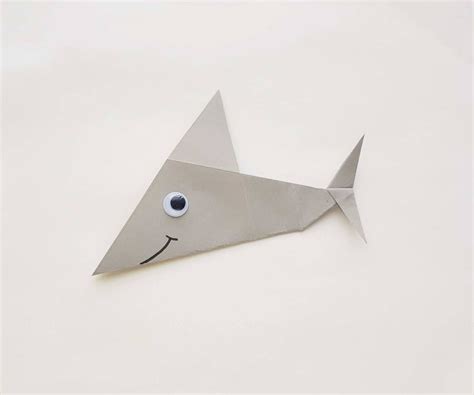 Make your own origami shark with this easy shark origami tutorial. Image of a paper shark with a ...