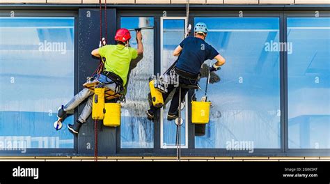 Two men cleaning windows on an office building Stock Photo - Alamy