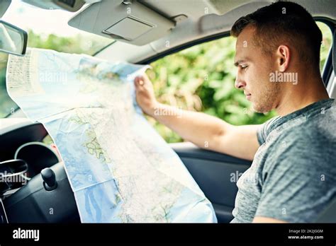 Où suis-je ? photo d'un jeune homme qui lit une carte tout en voyageant en voiture Photo Stock ...