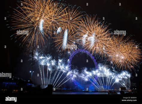 The London Eye lit up by fireworks on New Years eve 31st December 2010 ...