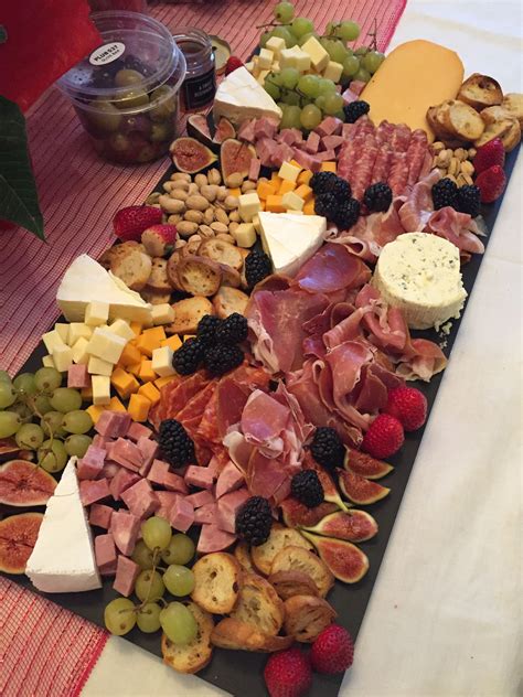 A deluxe charcuterie platter with a variety of meats, cheeses and fruit ...