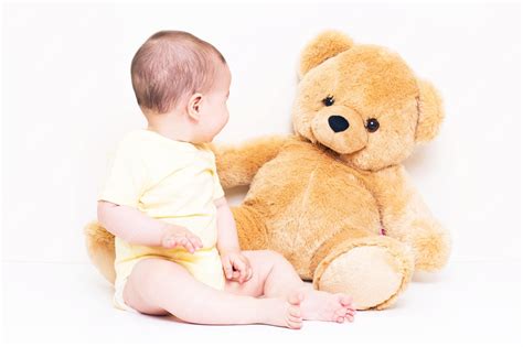 Premium Photo | Beautiful baby playing with a bear toy