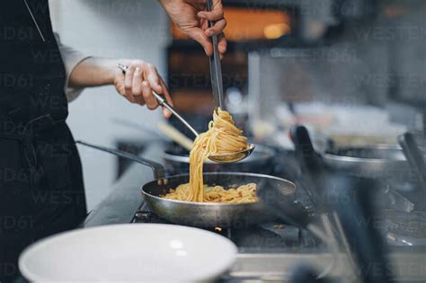 Chef preparing a pasta dish in traditional Italian restaurant kitchen stock photo