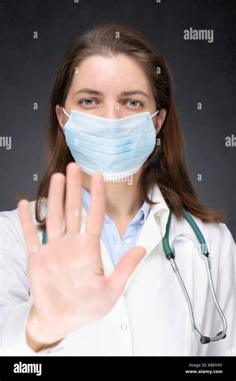 Female doctor in face mask showing stop sign with her hand Stock Photo - Alamy