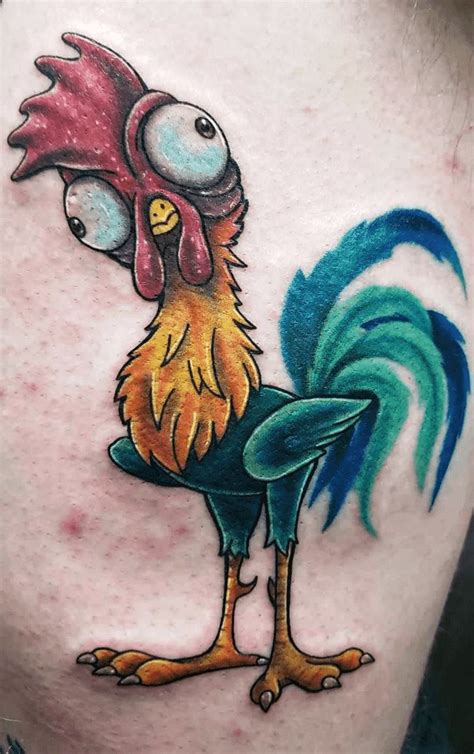 a colorful rooster tattoo on the thigh