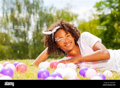 Portrait of a young girl laying in the lawn grass Stock Photo - Alamy