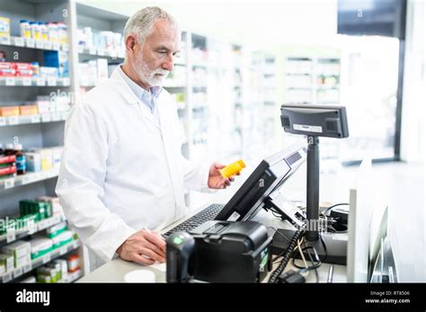 Pharmacist with medicine at counter in pharmacy Stock Photo - Alamy