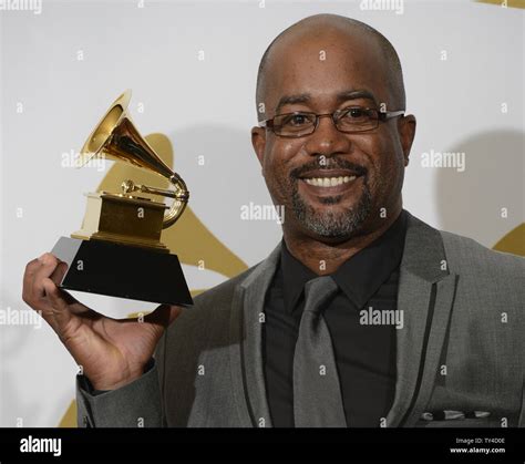 Darius Rucker holds his Grammy Award for Best Country Solo Performance along side his wife Beth ...