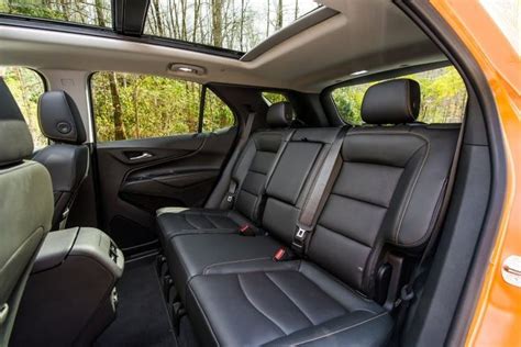 the interior of a car with black leather seats and trees in the back seat area