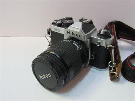 Nikon FM2 camera body and lens on an Olympus strap. Estimate £100-200.