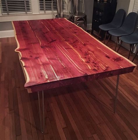 Custom 3" thick Eastern Red Cedar live edge dining table finished with hairpin legs. This table ...