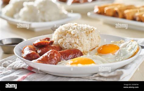 filipino silog breakfast with garlic fried rice, longsilog, and two sunny side up eggs Stock ...