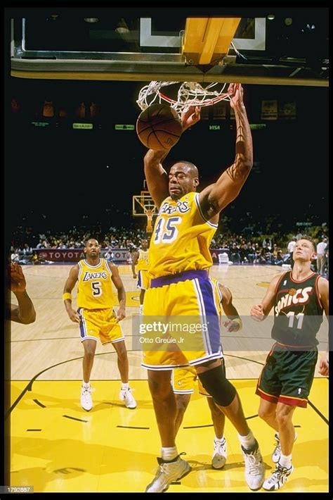 Sean Rooks of the Los Angeles Lakers dunks the ball past the defense ...