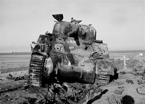 Knocked-out Sherman tank of 3rd County of London Yeomanry hit by a 75mm AT gun on the road to ...