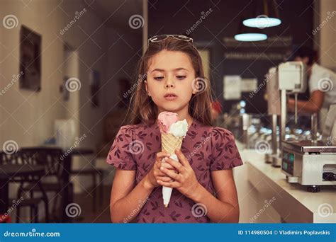 Beauty Little Girl in a Fashionable Dress Eating Strawberry, Standing ...