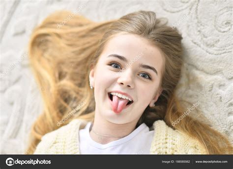 Portrait Beautiful Teen Girl Lying Floor Showing Tongue Stock Photo by ©aletia 188585562