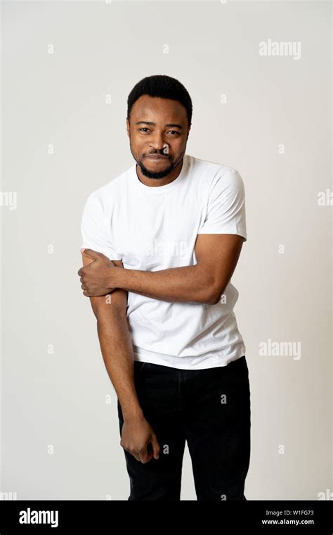 Half length portrait of attractive shy young african american man with happy face flirting with ...