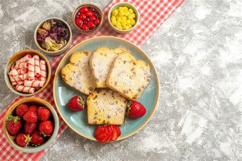 Free Photo | Top view cake slices with fresh strawberries and candies ...