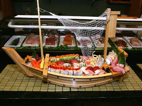 a wooden boat filled with lots of different types of food on top of a counter