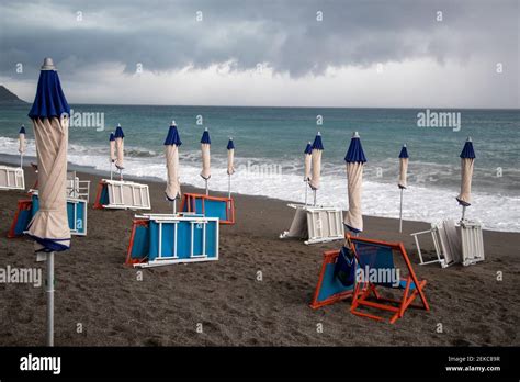 Leerer Strand mit geschlossenen Sonnenschirmen und zugeklappten Liegen in Cavi di Lavagna ...