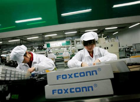 FILE PHOTO: Employees work inside a Foxconn factory in the township of ...