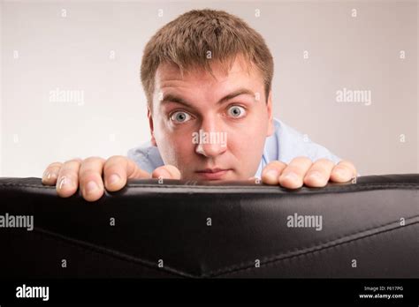 A young man hiding behind a office chair Stock Photo - Alamy