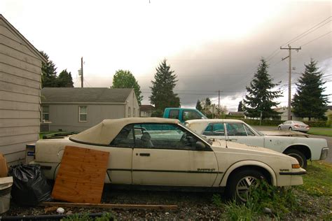 OLD PARKED CARS.: 1988 Pontiac Sunbird GT Turbo Convertible.