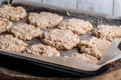 Oatmeal cookies dough with apples and dried apricots on a baking sheet ...