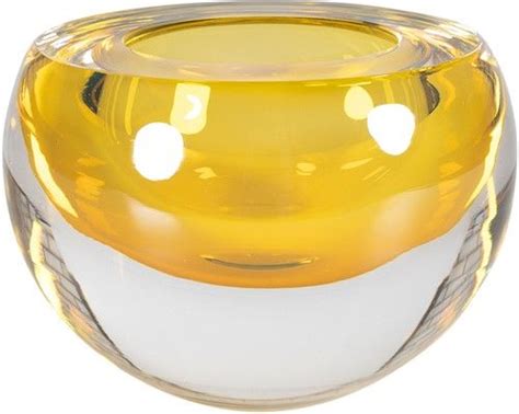 a yellow and white glass vase sitting on top of a table