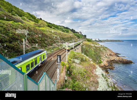 Two Dublin DART trains approach each other beside Killiney Bay, County Dublin, Ireland Stock ...