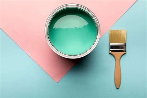 Premium Photo | Top view of tin with green paint and brush on blue and pink surface