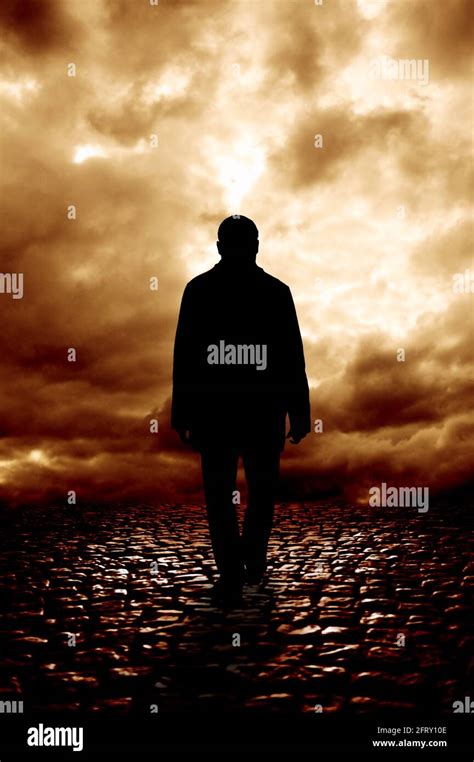 mysterious silhouette of a man walking away in a dark land Stock Photo - Alamy