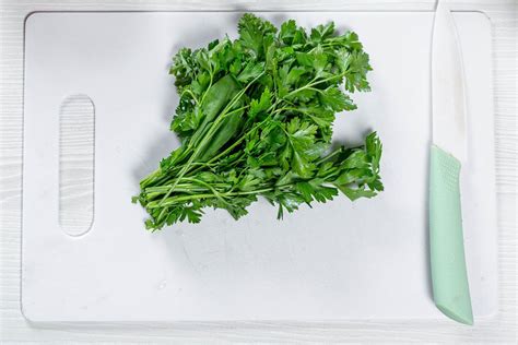 Fresh green parsley with a ceramic knife on a white kitchen Board - Creative Commons Bilder