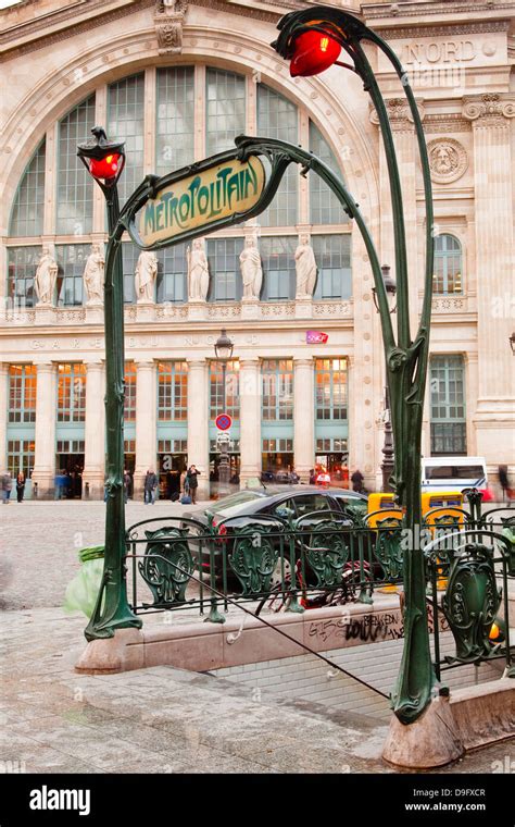 The art nouveau entrance to Gare du Nord metro station with the main railway station behind ...