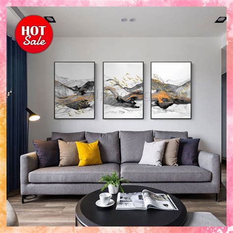 a living room with three paintings on the wall