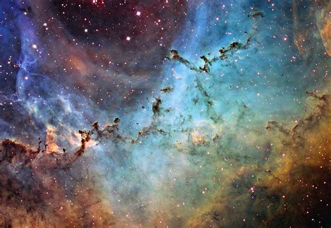 What creates the cosmic dust sculptures in the Rosette Nebula? Visible above are globules of ...