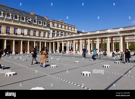 Palais Royal, 17th-century arcaded palace with gardens, people in Colonnes de Buren art ...