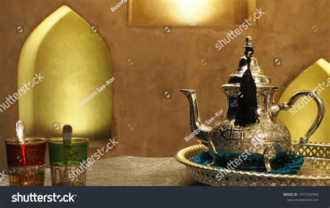 Traditional tea pot contained Moroccan mint tea with blurred red and ...