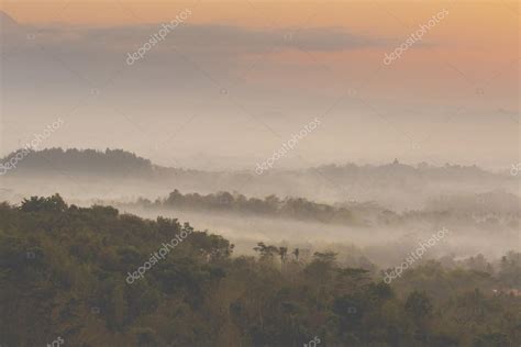 Colorful sunrise over Merapi volcano and Borobudur temple in mis Stock ...