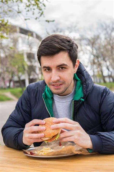 A Portrait of Young Man Eating a Burger Stock Photo - Image of dinner ...