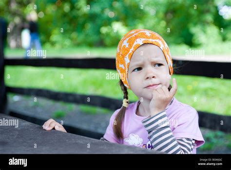 Girl sitting at picnic table Stock Photo - Alamy