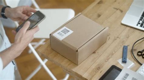Man Taking Photo of the QR Code on the Box · Free Stock Video