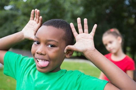 Premium Photo | Cute little boy making silly faces outside