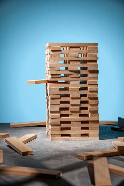 Premium Photo | Jenga game, a tower of wooden blocks on blue