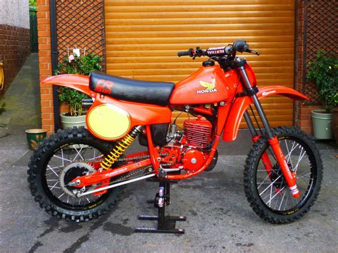 an orange dirt bike parked in front of a garage